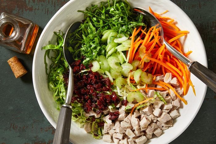 romaine, spinach, carrot, celery, dried cherries and pork in a large bowl
