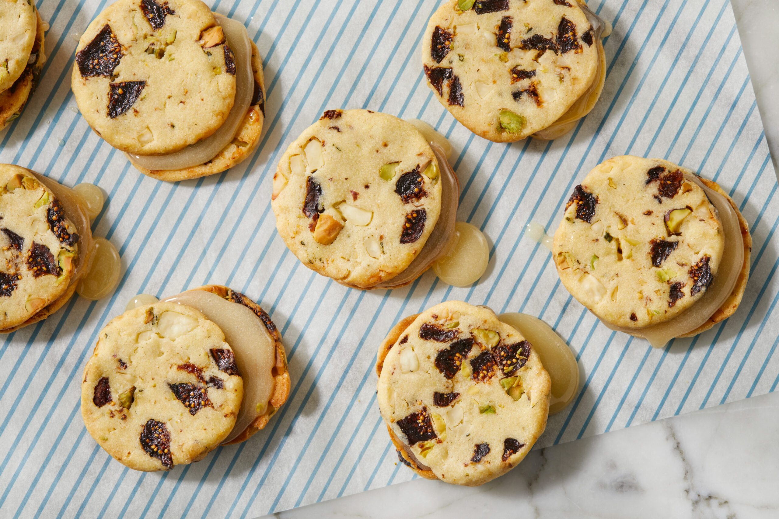 Overhead view of baked biscuit rounds arranged on a cloth-lined surface, highlighting the texture and mix-ins before filling.