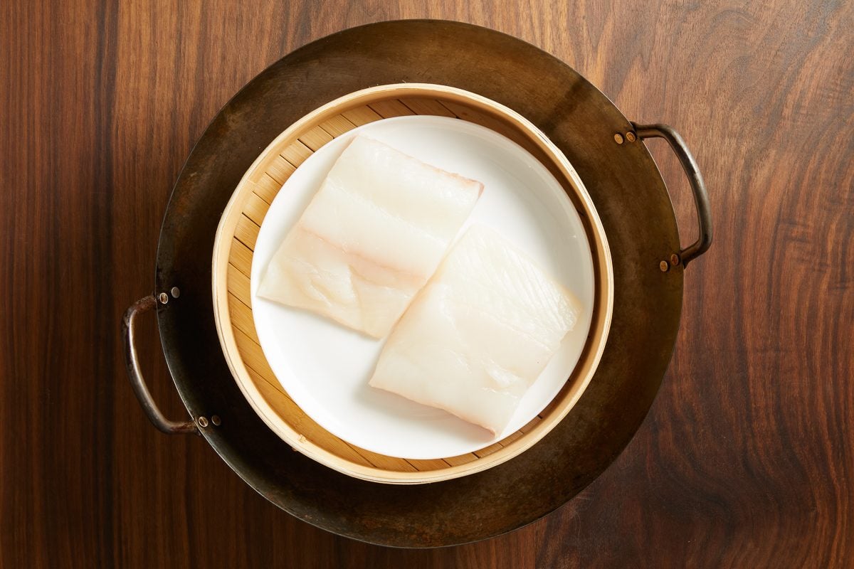 fish on a heatproof plate inside steamer