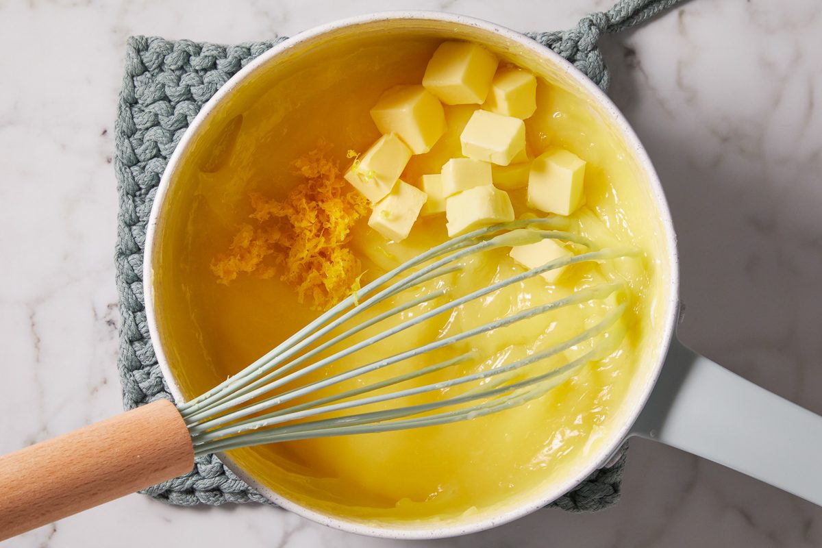 butter and lemon zest added to egg yolk mixture in a pan