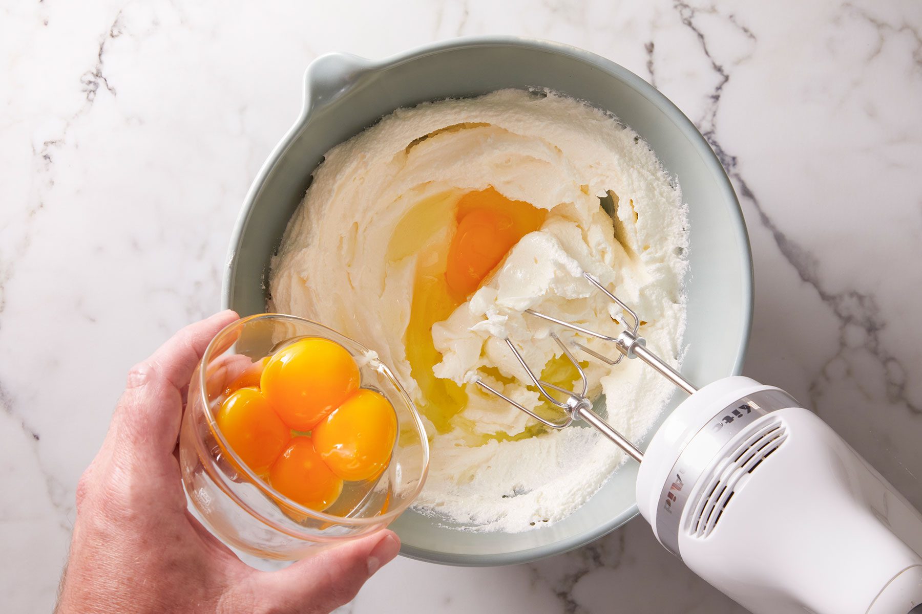 Creaming butter and sugar and adding egg yolks and beating them all together.