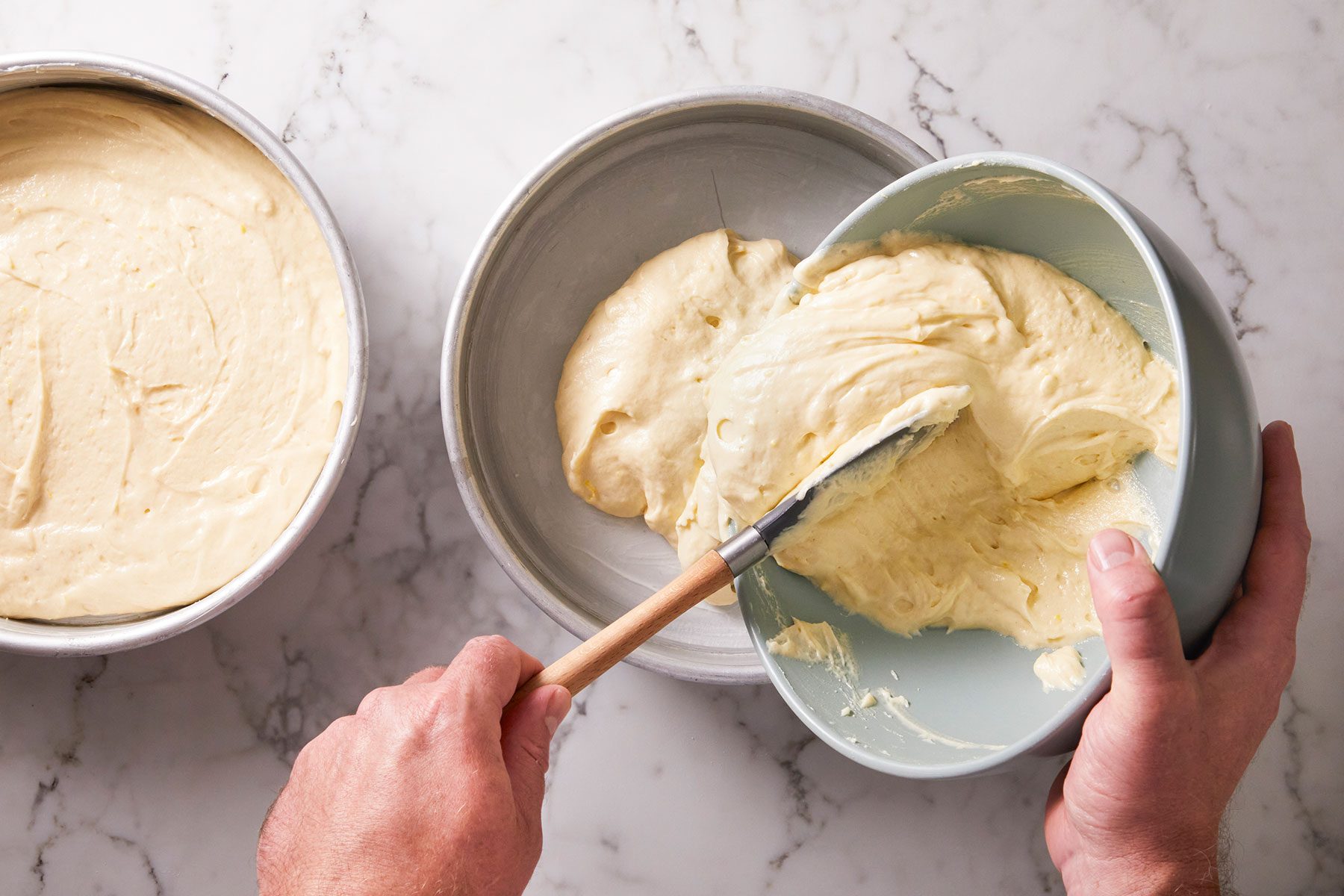 Adding strawberry lemonade cake batter into baking ready pans.