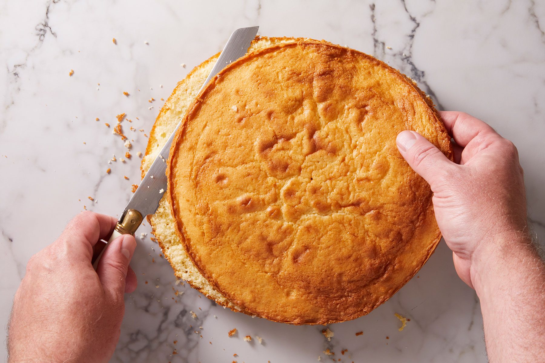 Cutting a cake into two halves with a long knife.