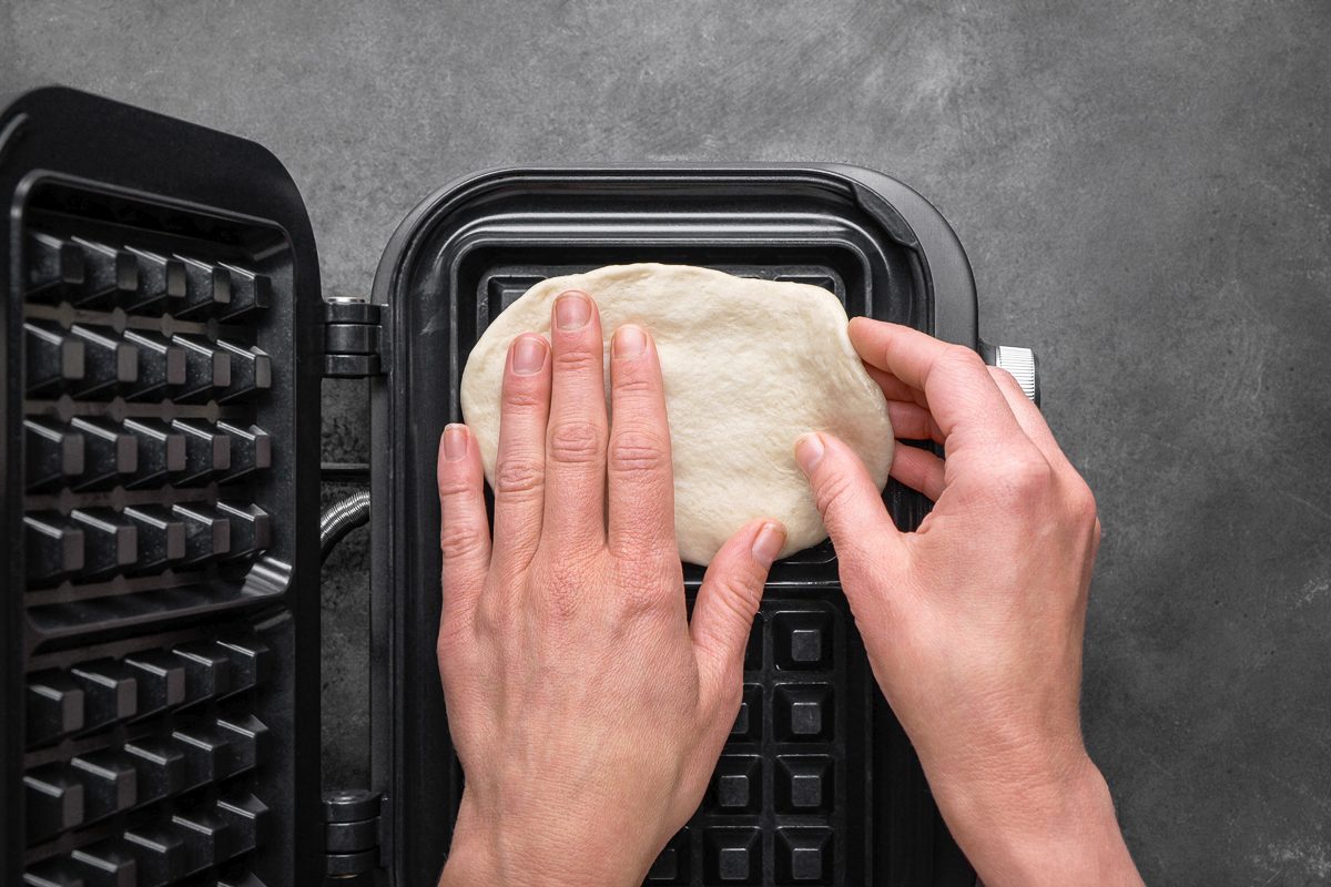 pressing biscuits into waffle maker