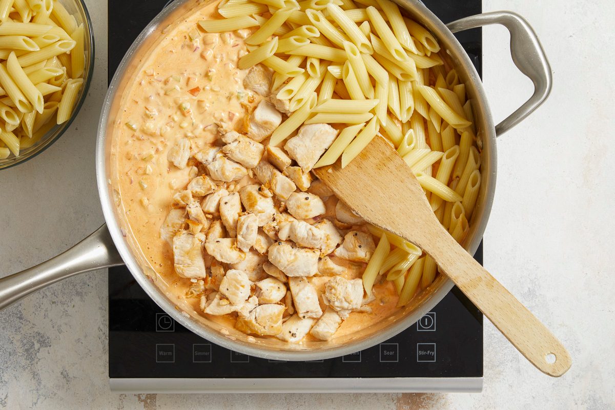 pasta and chicken added to blue cheese salad dressing, mayonnaise and hot sauce mixture in skillet