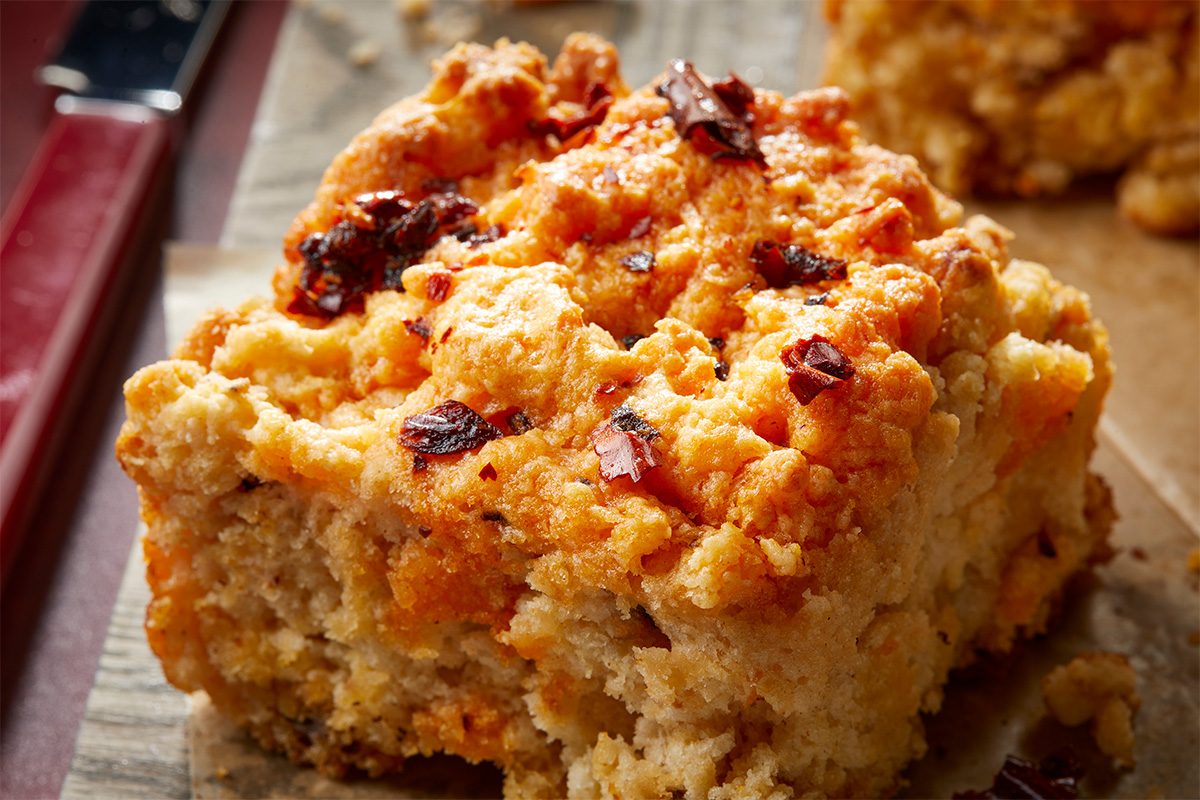 Close-up overhead image of a chili crisp biscuit square showing the tender crumb and spicy chili crisp topping.