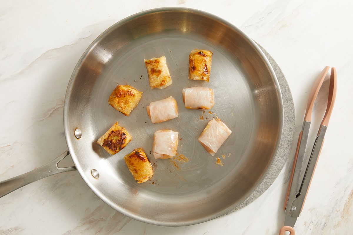 dumplings being sautéed in a skillet