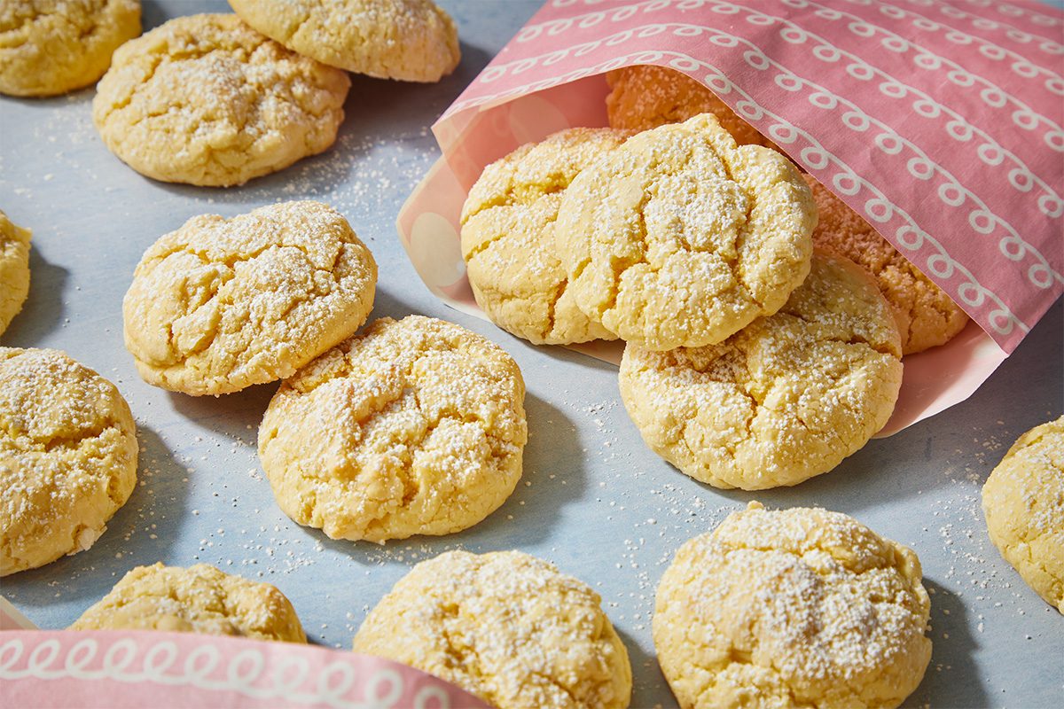 Overhead image of baked butter cookies presented in pink patterned parchment paper, styled for sharing and gifting at a cookie exchange or holiday gathering.