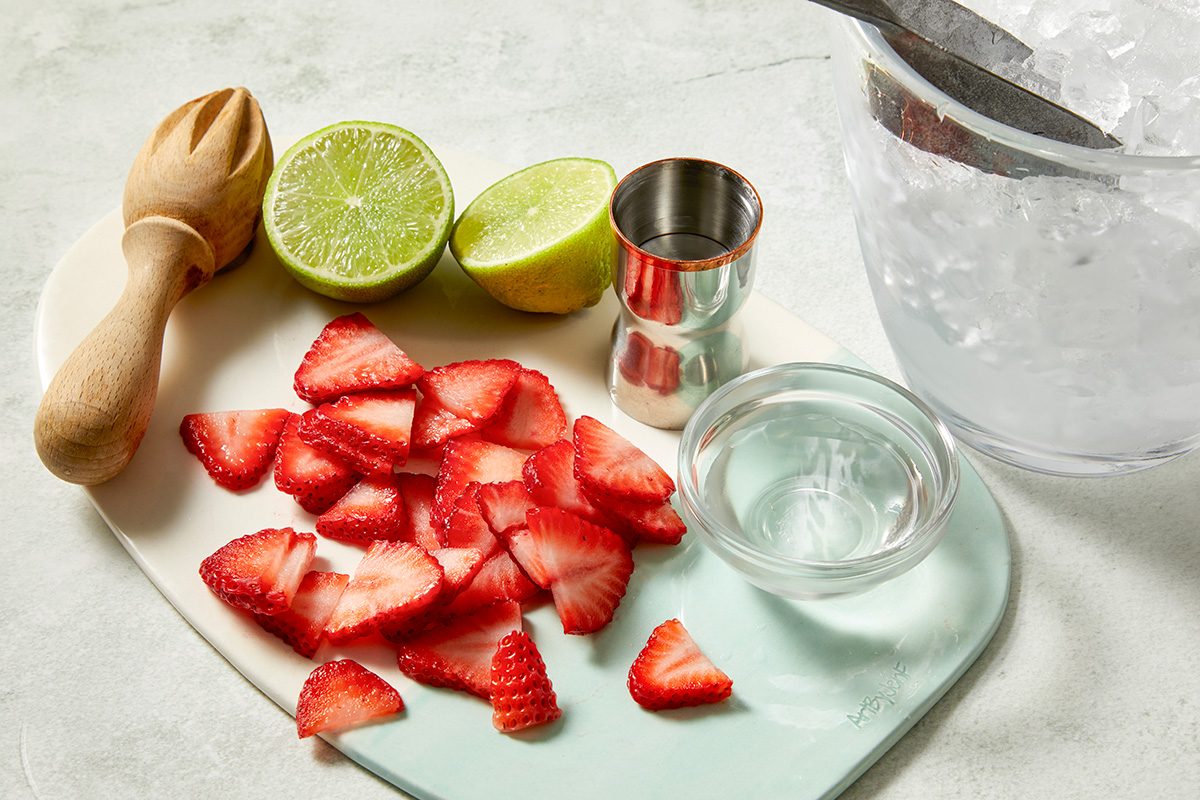 Overhead fast-track preparation shot of ingredients for a frozen strawberry daiquiri 