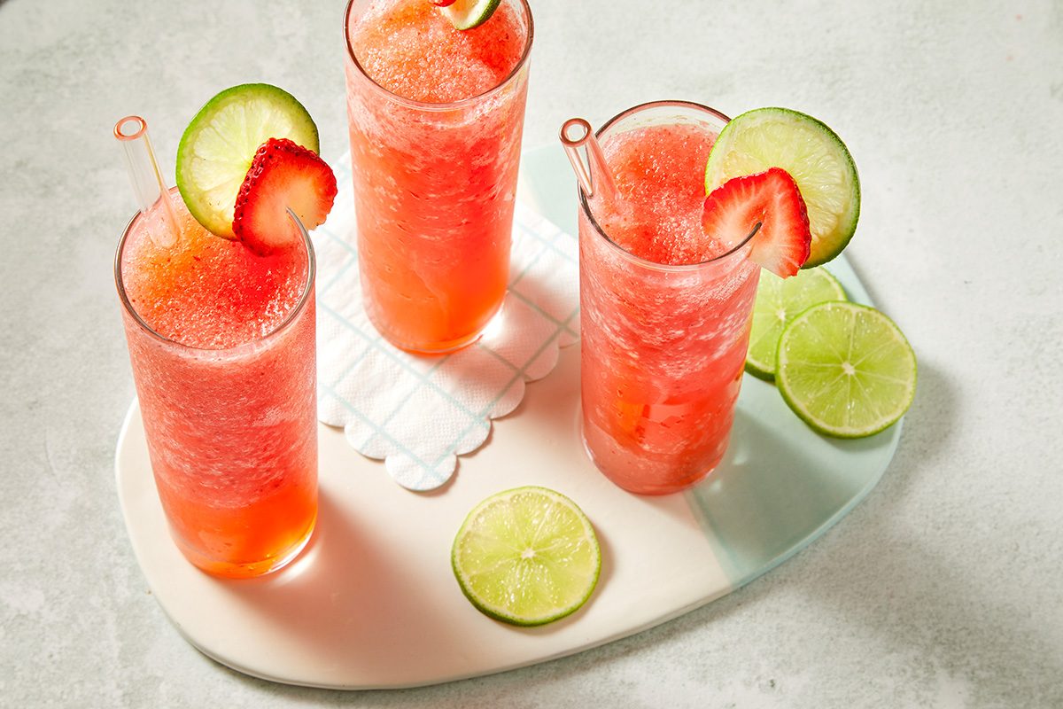 Three finished frozen strawberry daiquiris arranged on a tray 