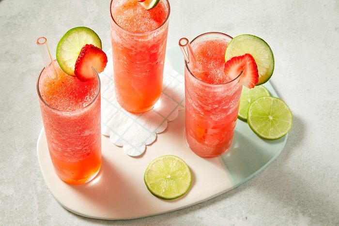 Three finished frozen strawberry daiquiris arranged on a tray