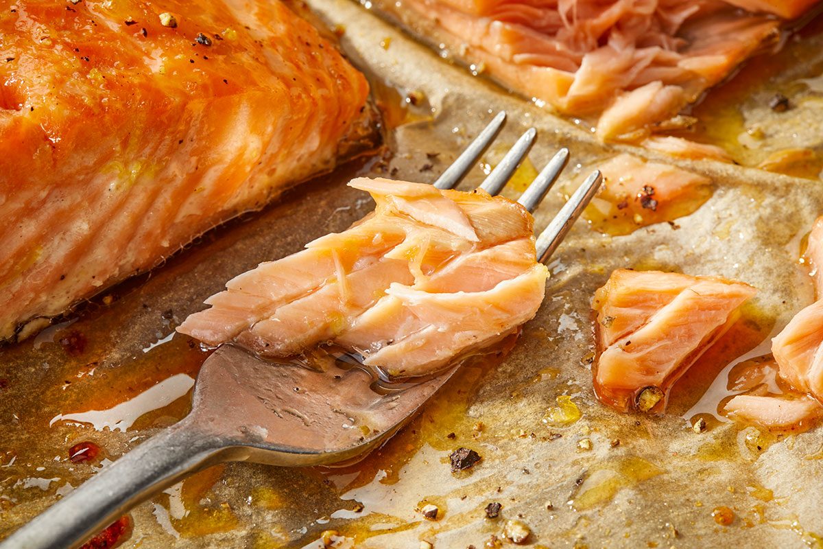 Overhead horizontal close-up of flaky hot honey glazed salmon showing texture and glaze