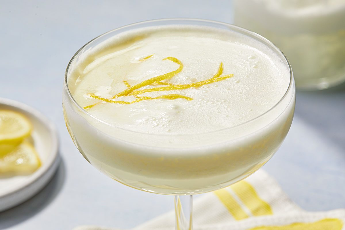 Overhead close-up of Lemon Cream Martini showing creamy foam texture and lemon zest garnish on top.