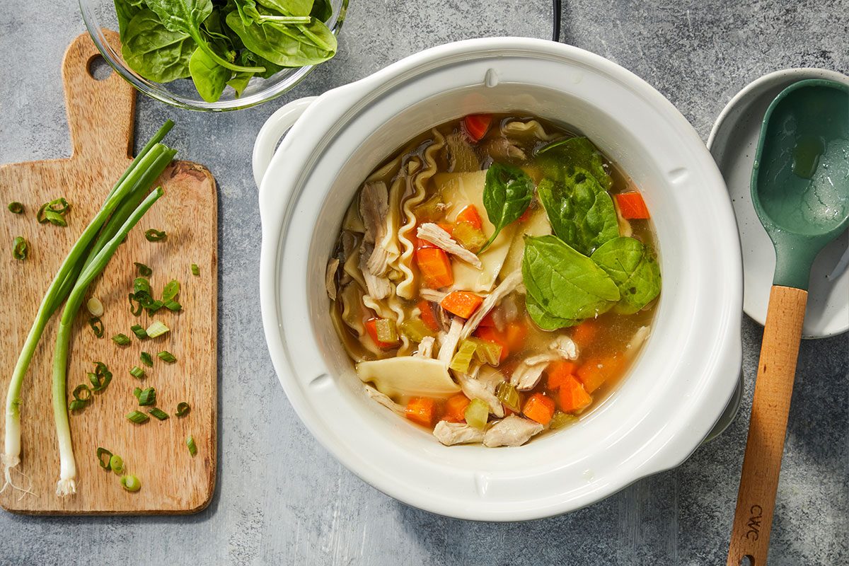 RMS 281394 Modern Slow Cooker Lemongrass Ginger Chicken Noodle Soup; How to; Step 2; Chicken and noodles cooked in slow cooker; remove lemongrass; Add spinach and green onions to soup