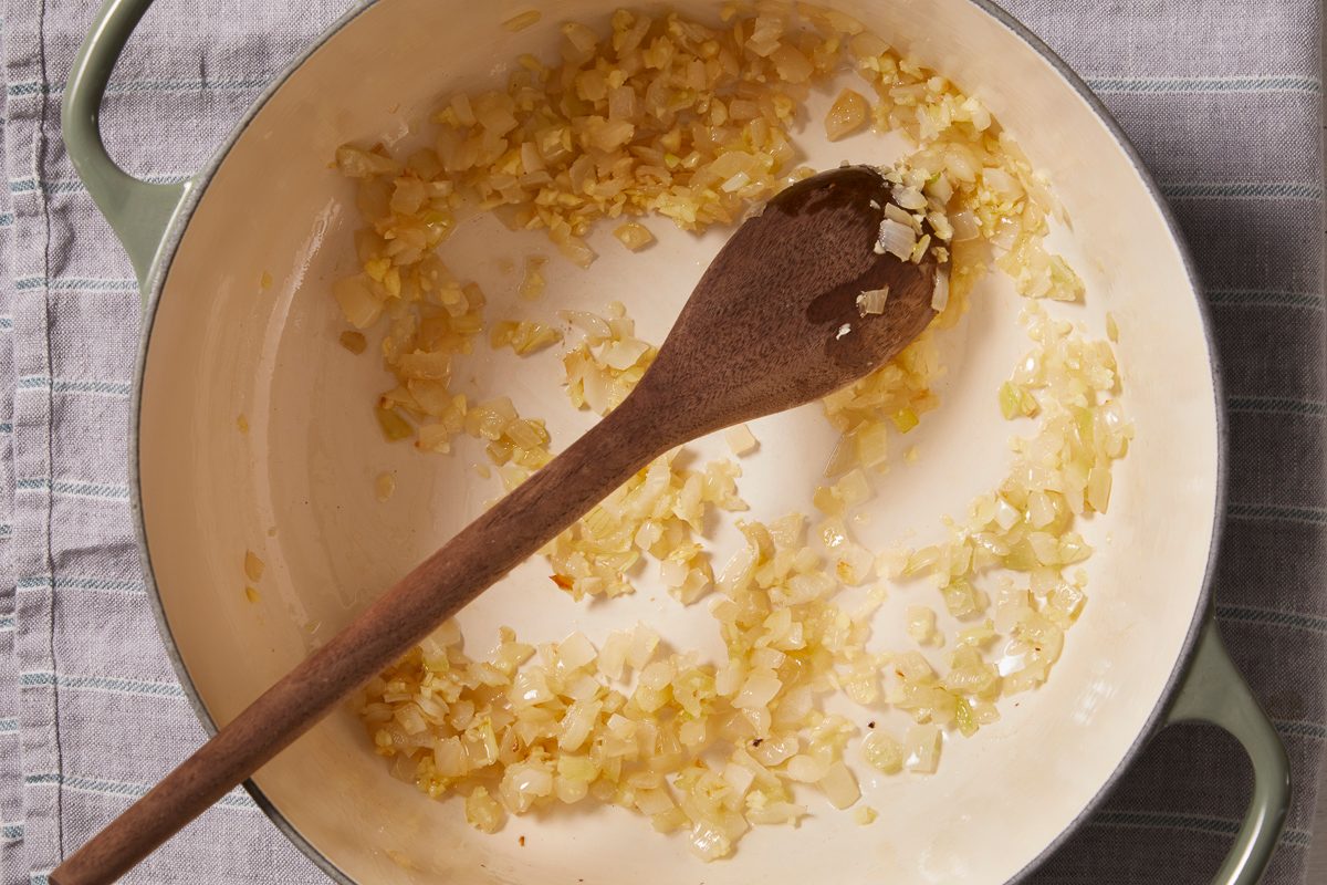 onions being cooked in a dutch oven