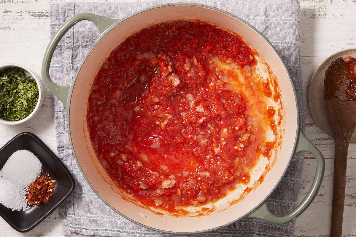 crushed tomatoes added to dutch oven and stirred with garlic and onions