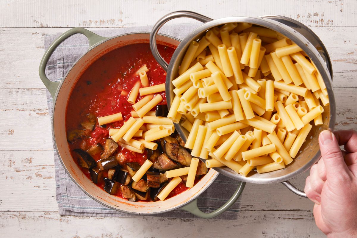 adding cooked pasta to sauce in dutch oven