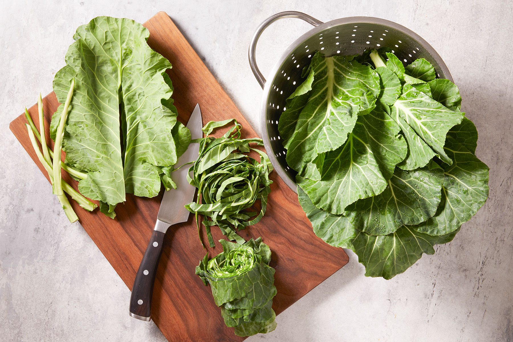 Stacking and rolling up washed collard leaves to cut them into thick strips.