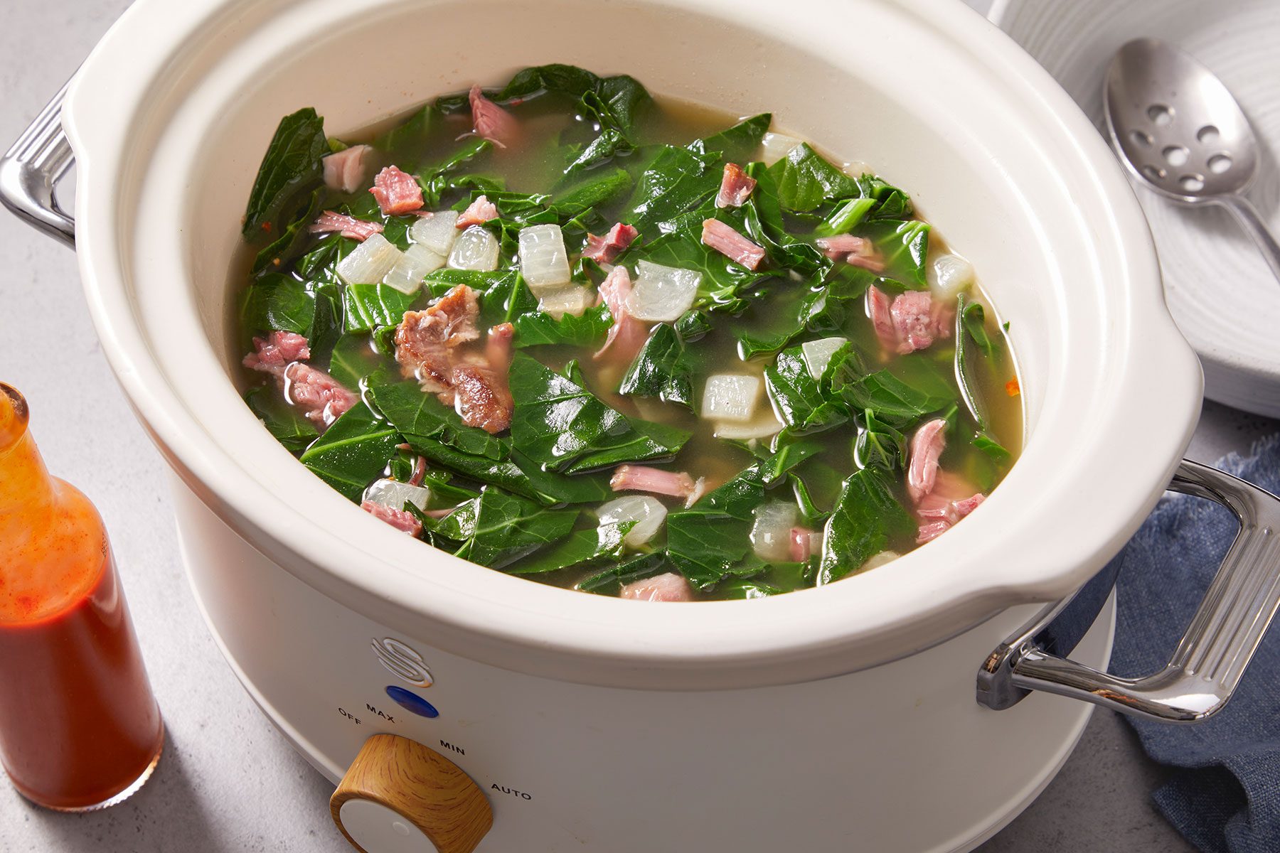 Slow Cooker Collard Greens in a slow cooker of white color.