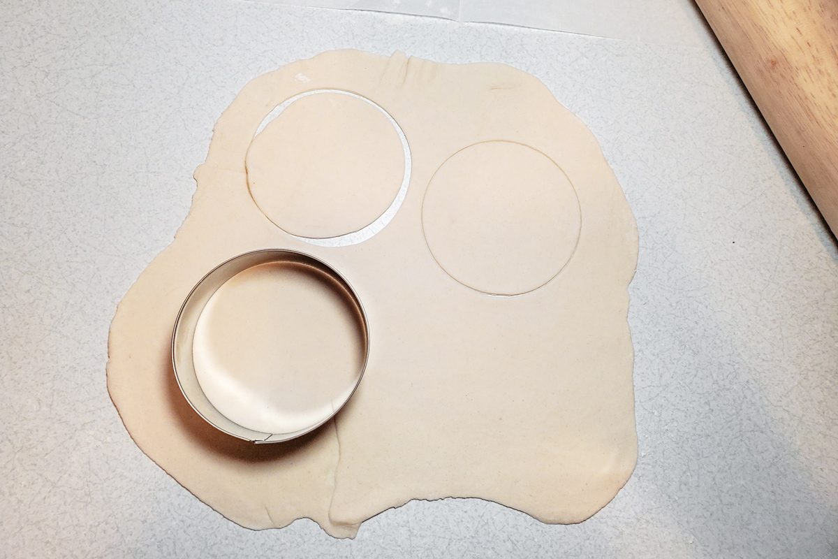 dough circle cutter on rolled out dough