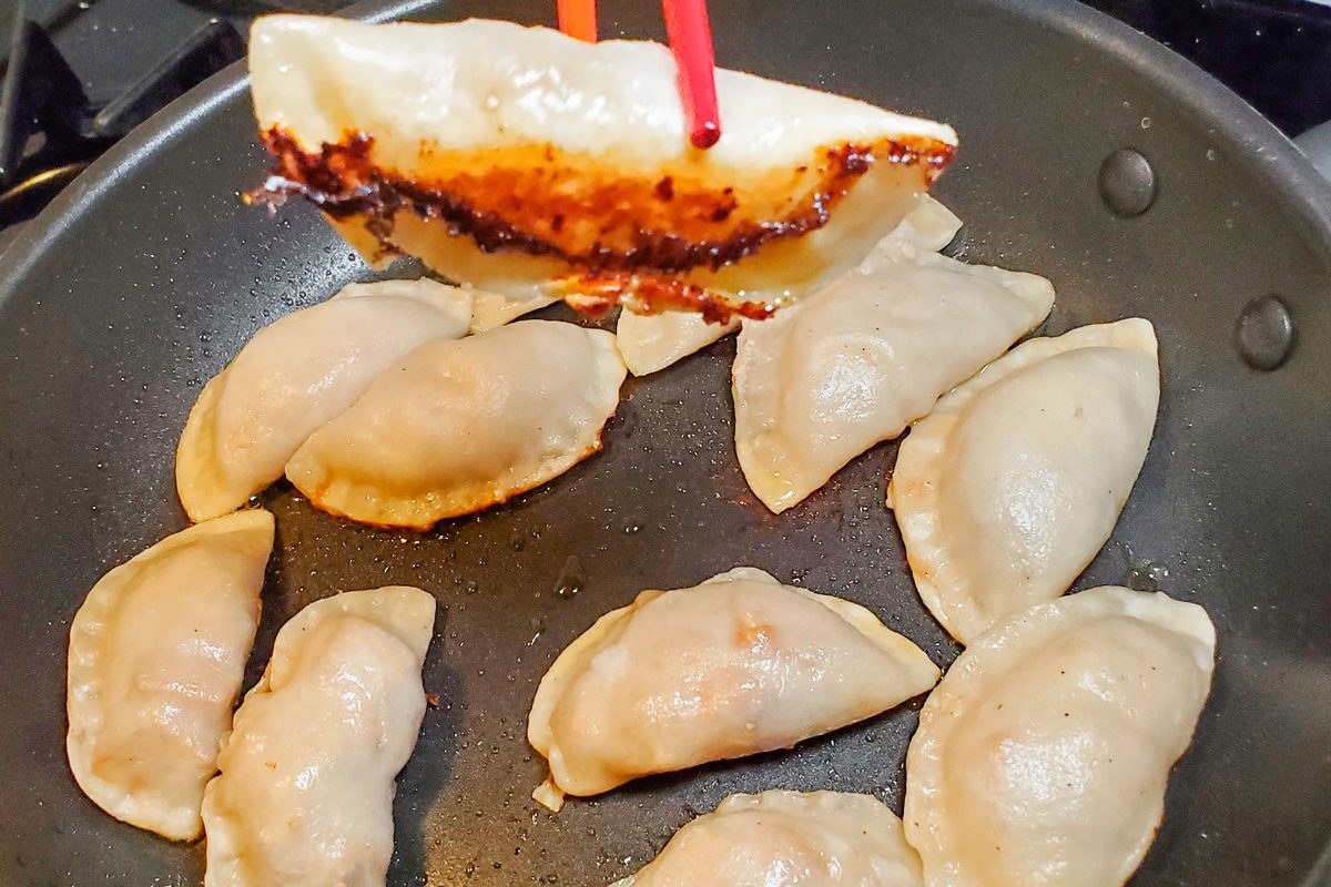 dumplings being cooked in a skillet