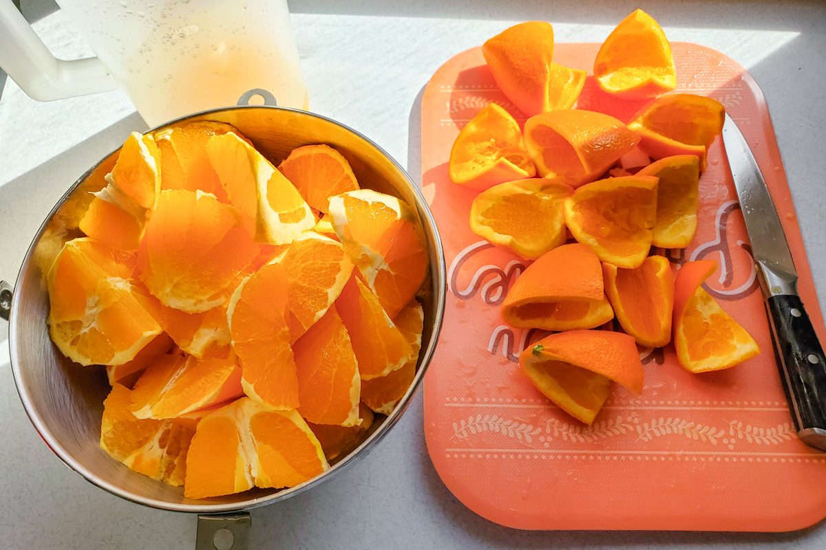 oranges in a bowl next to rinds