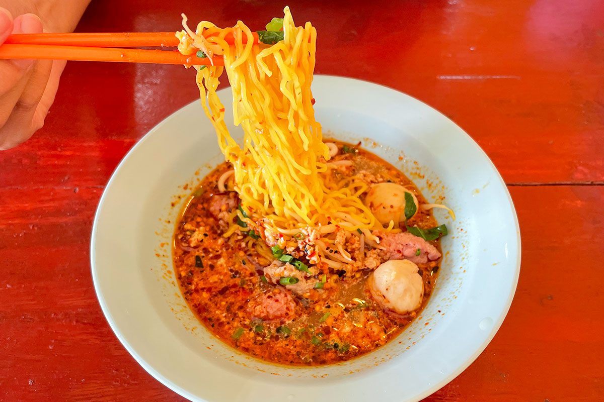 Spicy noodle, Yellow noodle with in a bow on a wooden table, Spicy food, Tom Yum soup 