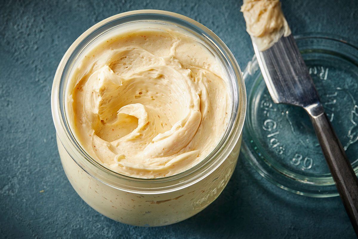 Overhead horizontal image of whipped hot honey butter being scooped with a knife