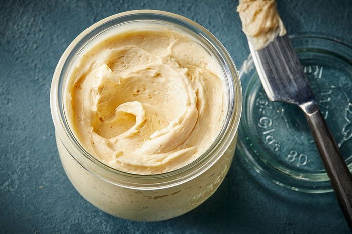 Overhead horizontal image of whipped hot honey butter being scooped with a knife