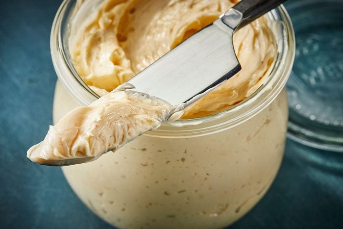 3/4 angle horizontal close up image of whipped hot honey butter being scooped with a knife