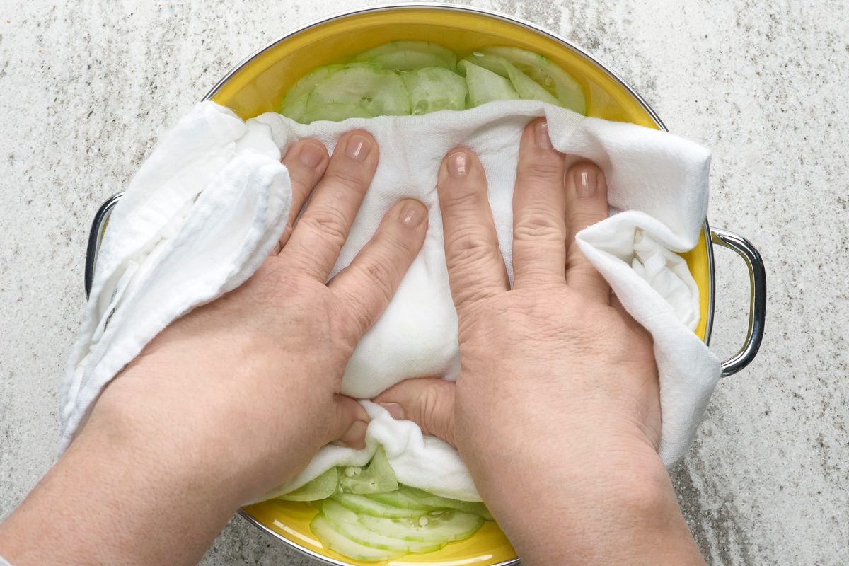 patting cucumbers with a cloth to drain excess liquid