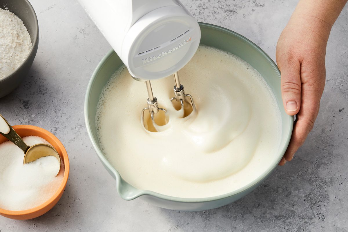 using a mixer to beat cream of tartar, vanilla extract, almond extract and salt together in a bowl