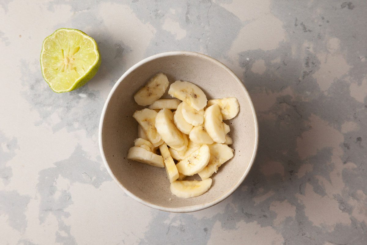 quartered banana and lime juice in a bowl