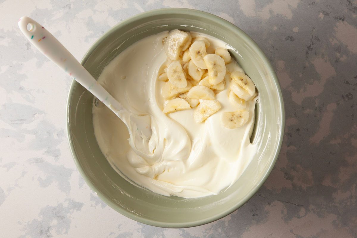 Bananas being mixed in the pudding mixture