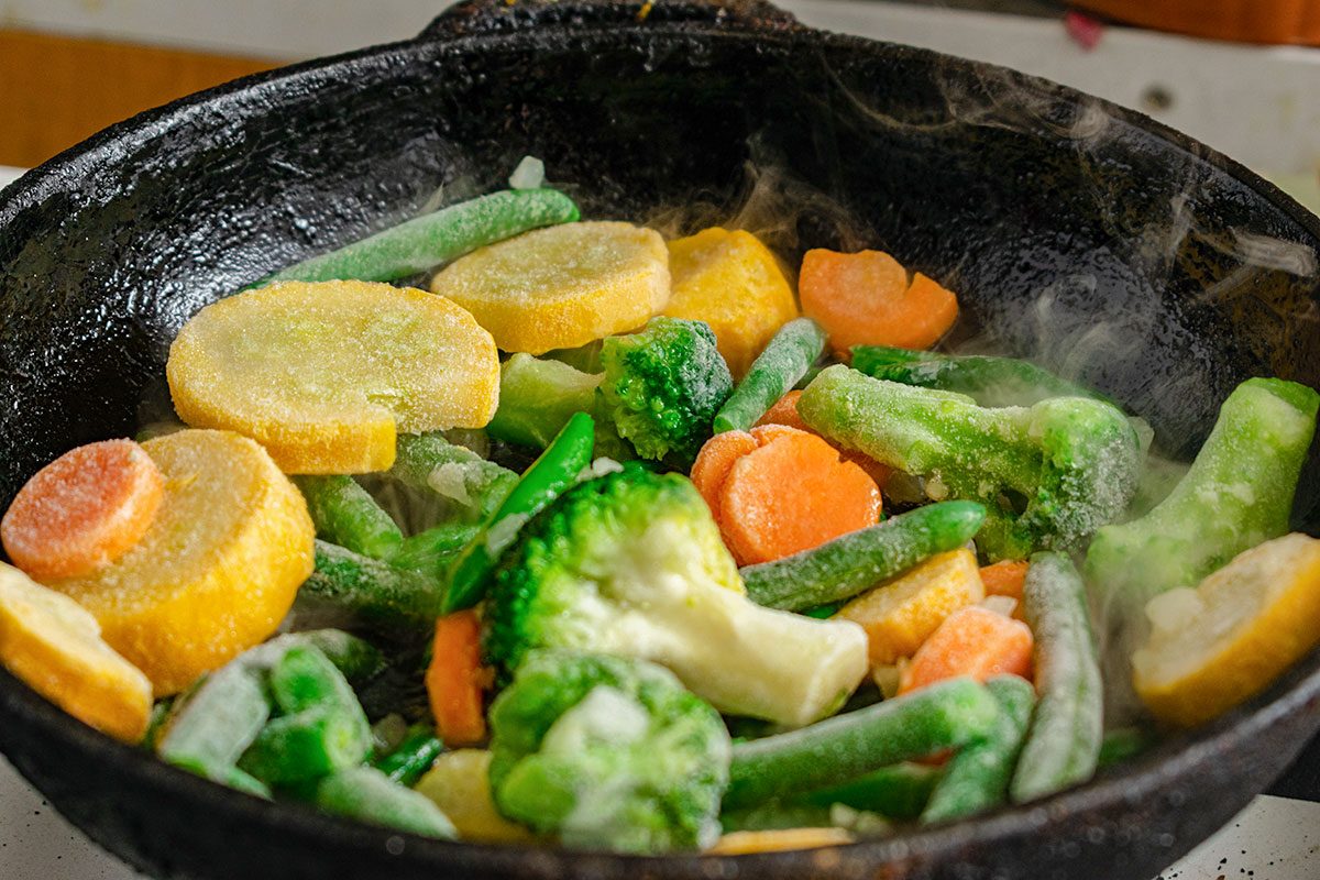 Frozen vegetables in a pan. Mix of different vegetables - carrots, green beans, cauliflower