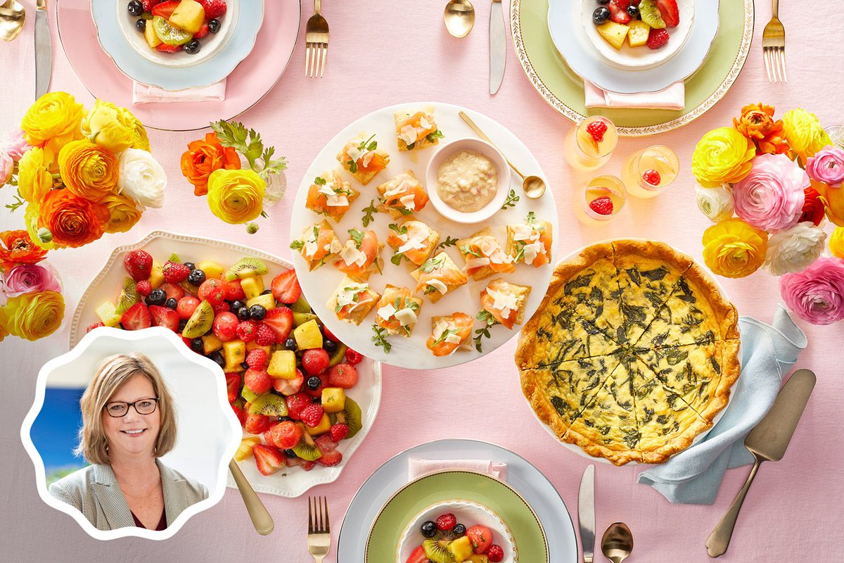 An overhead styled scene shows a pastel-toned brunch table with multiple plated dishes including fruit salad, quiche, desserts, appetizers, and sparkling beverages arranged on a light surface.
