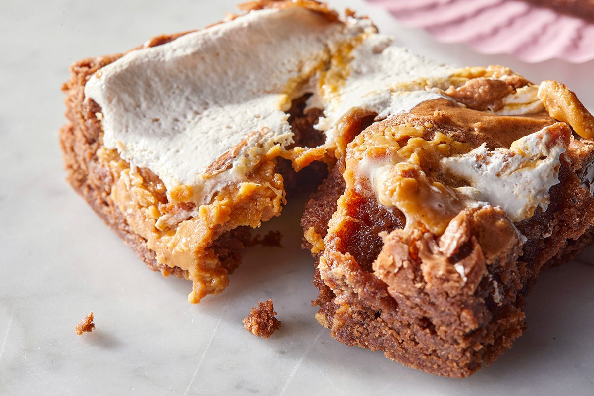  peanut butter marshmallow brownie that has been broken in half on a marble surface