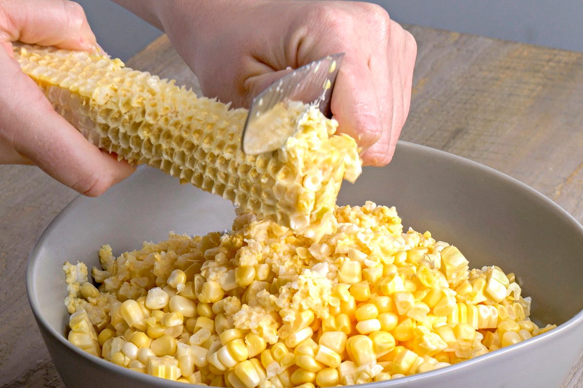 rubbing edge of knife over cob