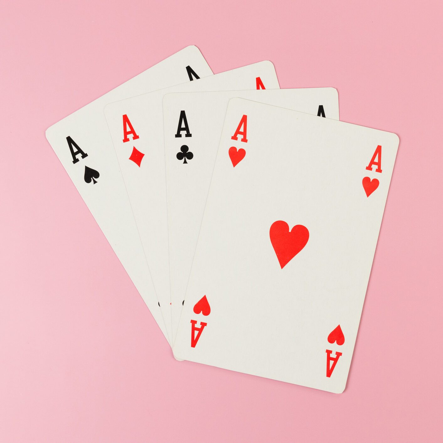Top view of playing cards on pink background. Four aces cards, board game, poker.