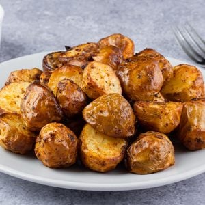 Crispy roasted baby potatoes served on a plate with dipping sauce