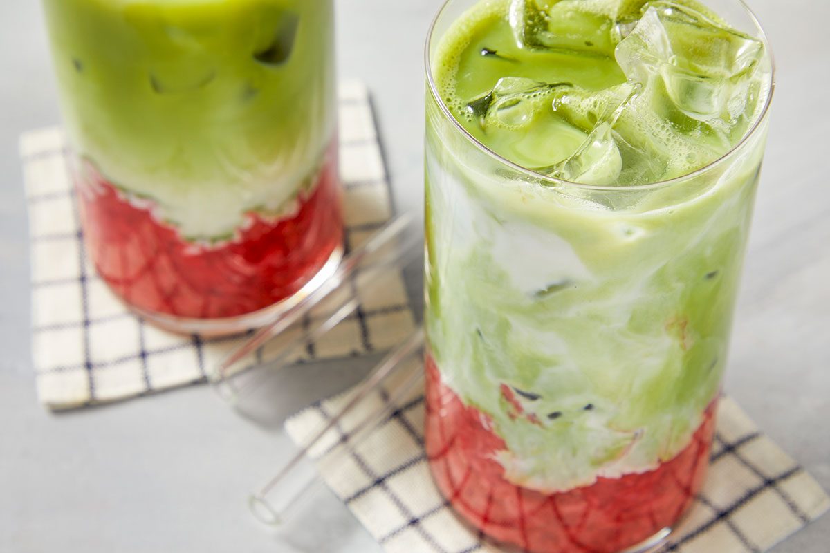 Finished strawberry matcha iced latte with partially mixed layers, showing a blend of strawberry, milk, and matcha in a single glass.