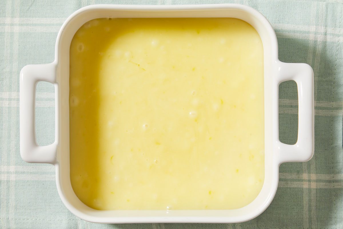 Overhead horizontal image of smooth lemon truffle mixture set in a dish, ready for shaping.