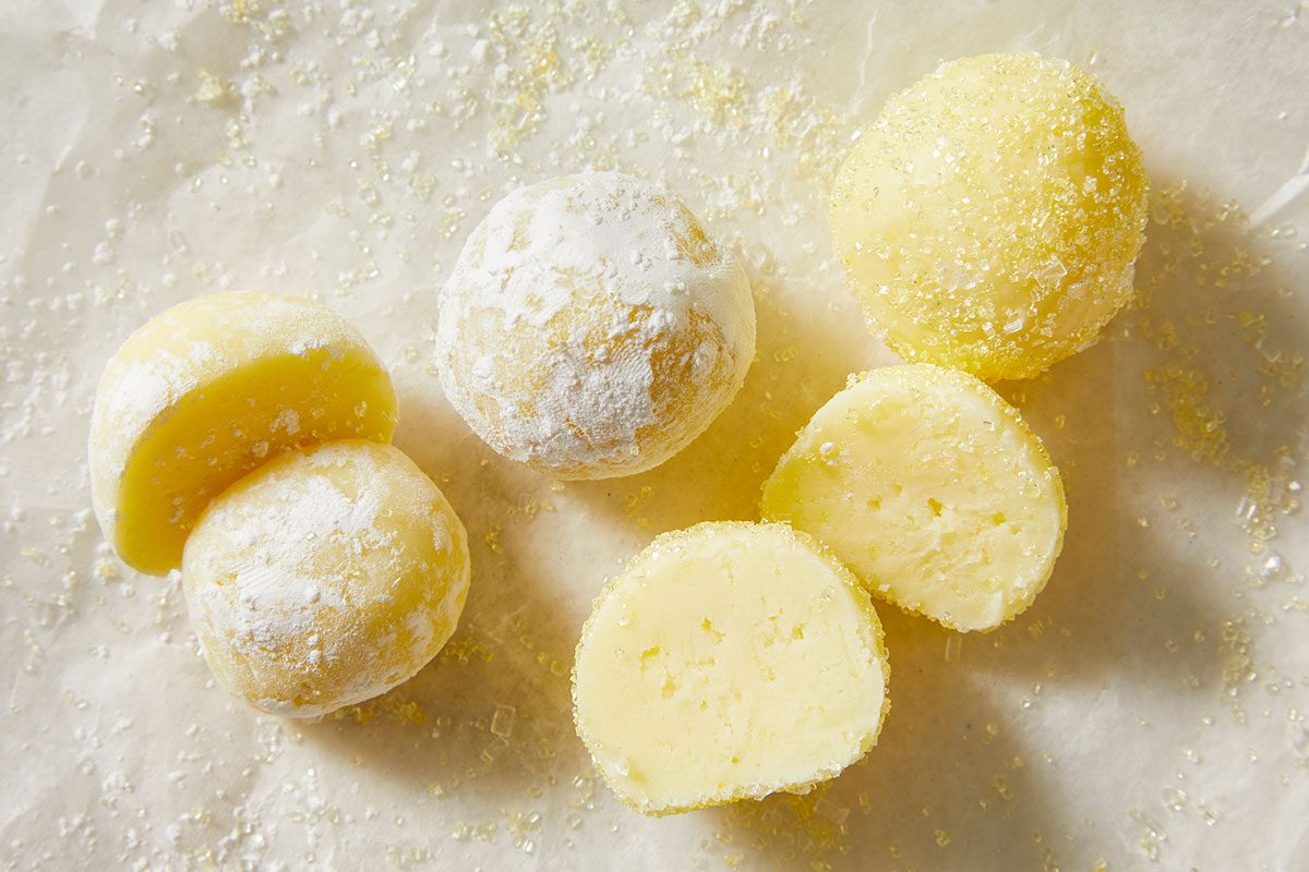 Eye-level horizontal close-up of lemon truffles showing smooth interior and sugar coating texture.