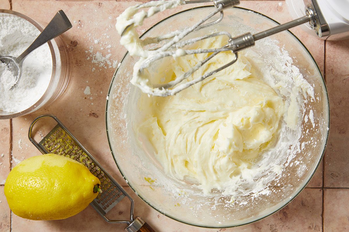 Overhead horizontal step-by-step image of lemon buttercream filling being mixed with lemon zest in a bowl.