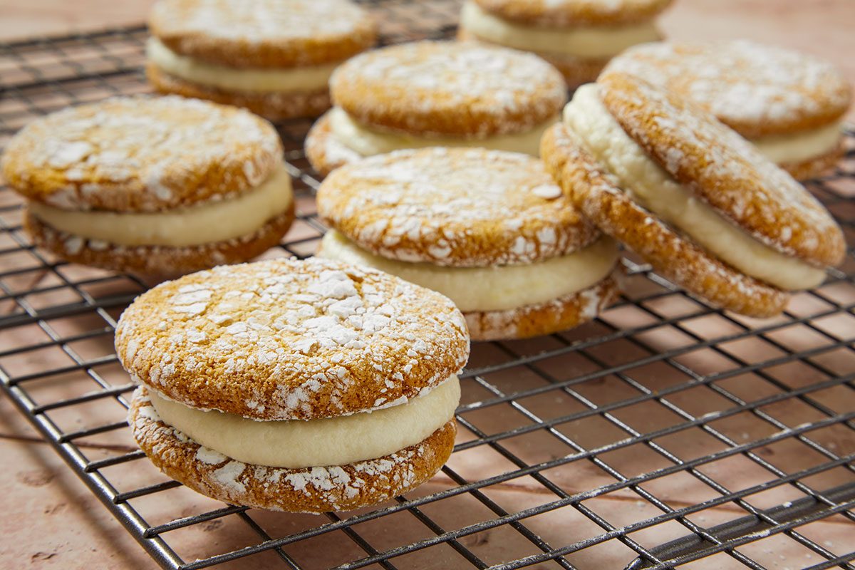 Overhead horizontal push and pulls image of plated limoncello sandwich cookies highlighting texture and creamy filling.