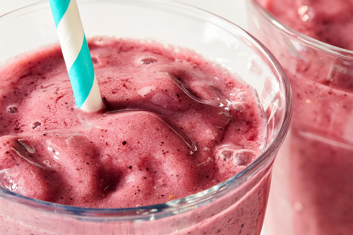 Close-up of a berry smoothie showing a thick, spoonable texture with visible fruit blending.