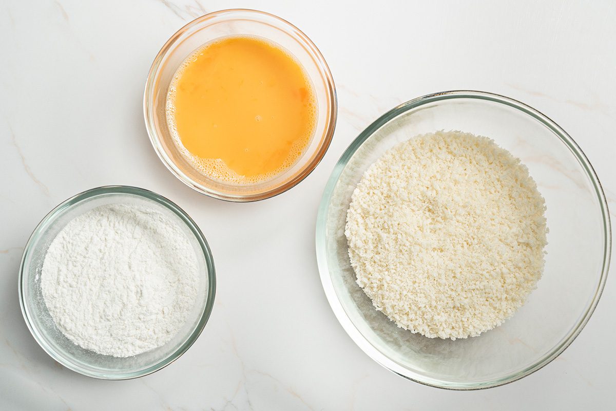 Overhead shot of three separate shallow bowls; place the flour, eggs and bread crumbs