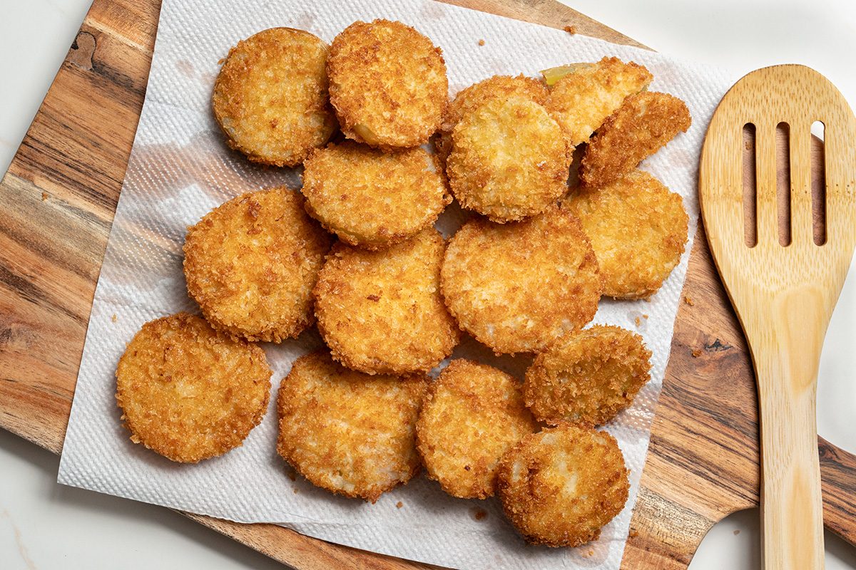 Overhead shot of fried tomatoes drain on paper towels