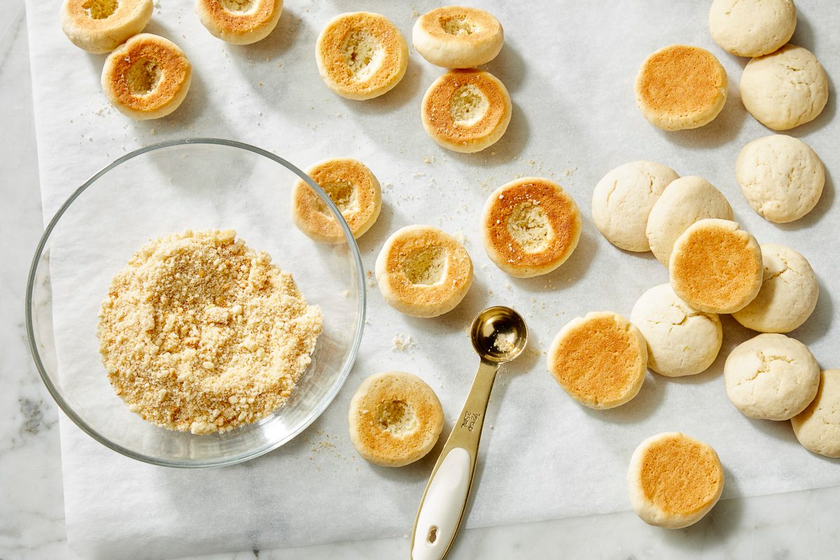Overhead view of baked peach cookies with centers indented and filled with peach preserves before assembly.