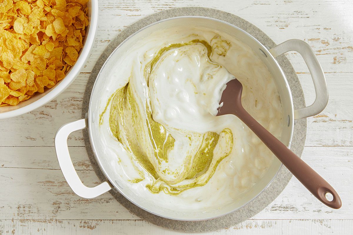 Butter and marshmallows are melted together in a pot and stirred until smooth and glossy.